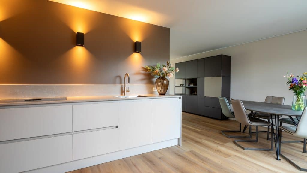 Strakke keuken zonder bovenkasten met een licht betonlook aanrechtblad